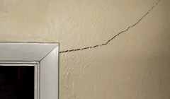 A corner crack next to a door frame in a home.