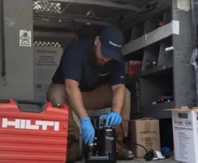 service tech inspecting a sump pump to see if it is running and shutting off when it is meant to turn off