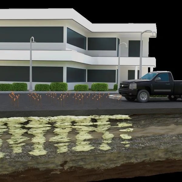 Cross-section of a building with a truck parked outside, showing underground contamination beneath the surface.